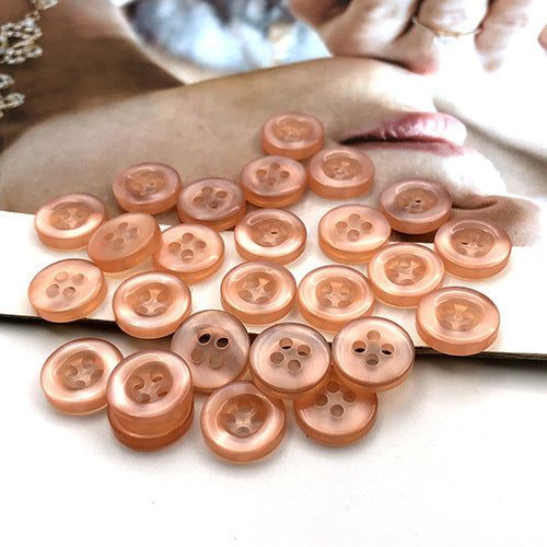 Peach/orange round 4-hole shirt buttons, multiple buttons with four holes