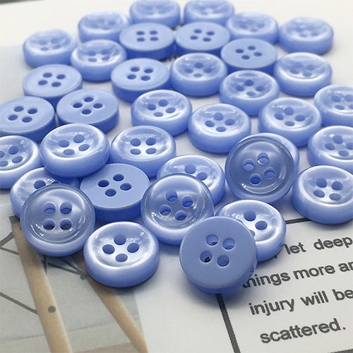 Blue round 4-hole shirt buttons, close view of button fronts and holes