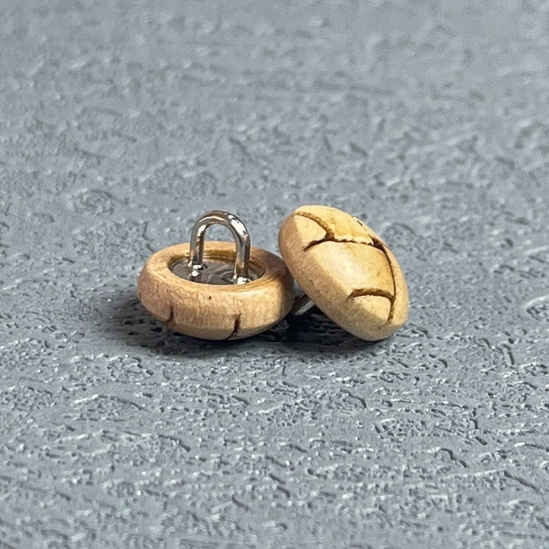 Round natural wood shank button with metal loop shank, cross-engraved design