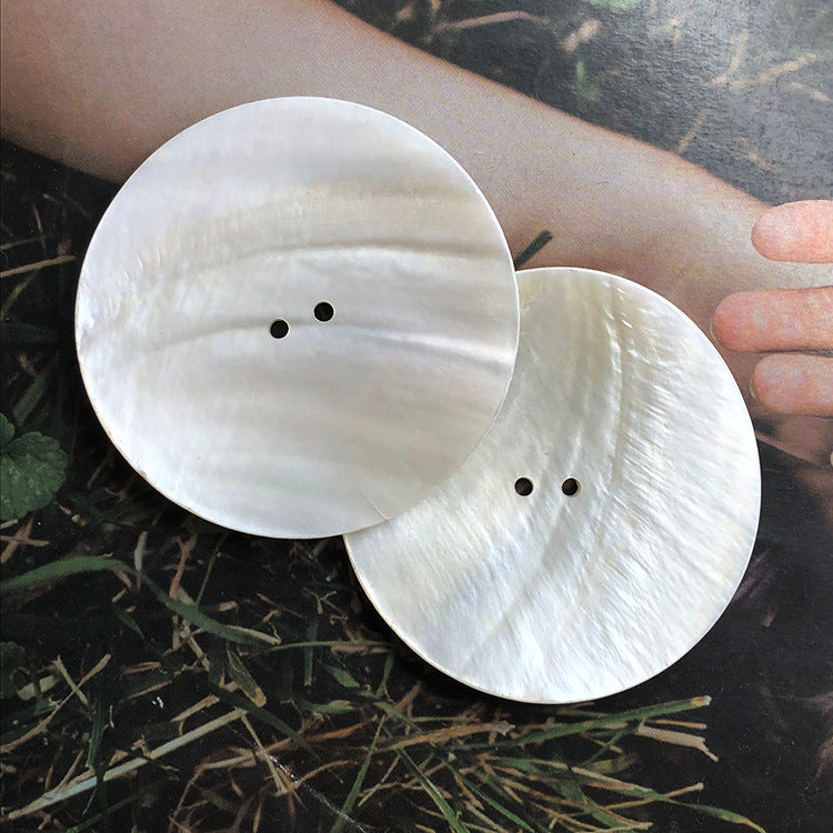 Two large white round two-hole shell buttons, 30–60mm, subtle striations