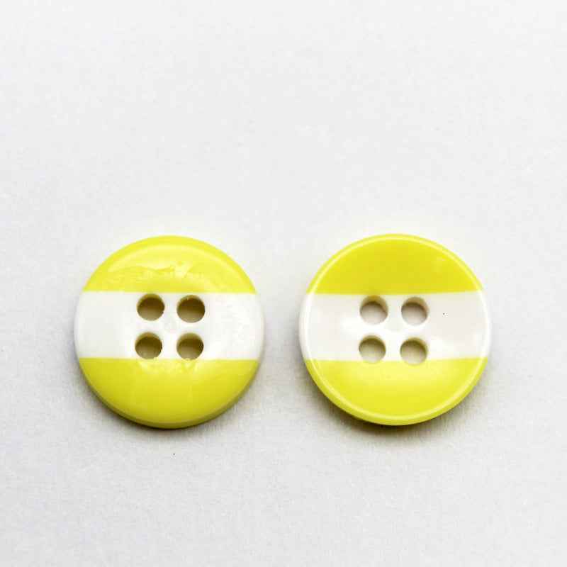 Round resin button with pale yellow top and bottom, white middle stripe; four holes.