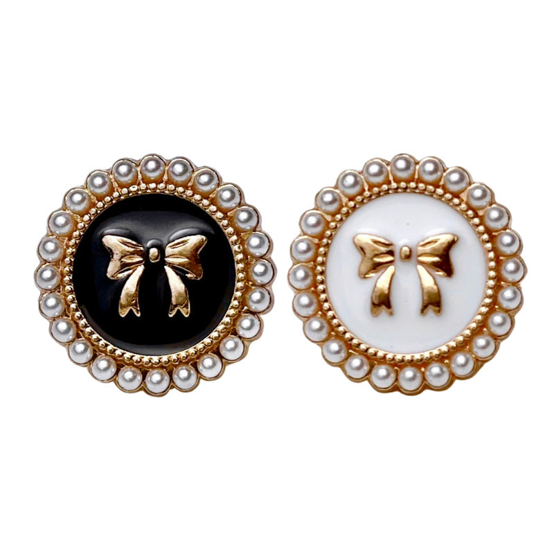 Bowknot pearl metal buttons: one black, one white with gold bow motif and pearl border