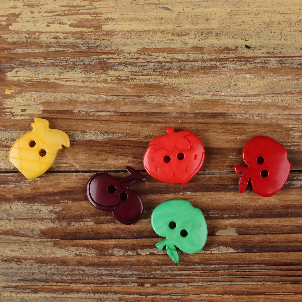 Fruit-shaped corozo buttons with dark purple, red, yellow, and green colors, mixed styles
