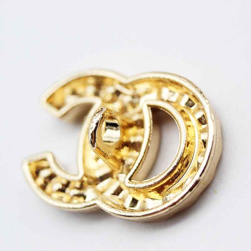 Gold-tone rhinestone C-shaped shank button, side view showing metal setting