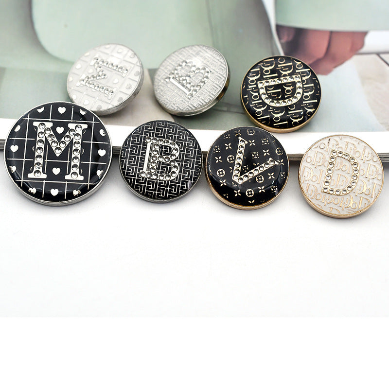 Round rhinestone letter buttons in black and white, with heart and geometric pattern accents