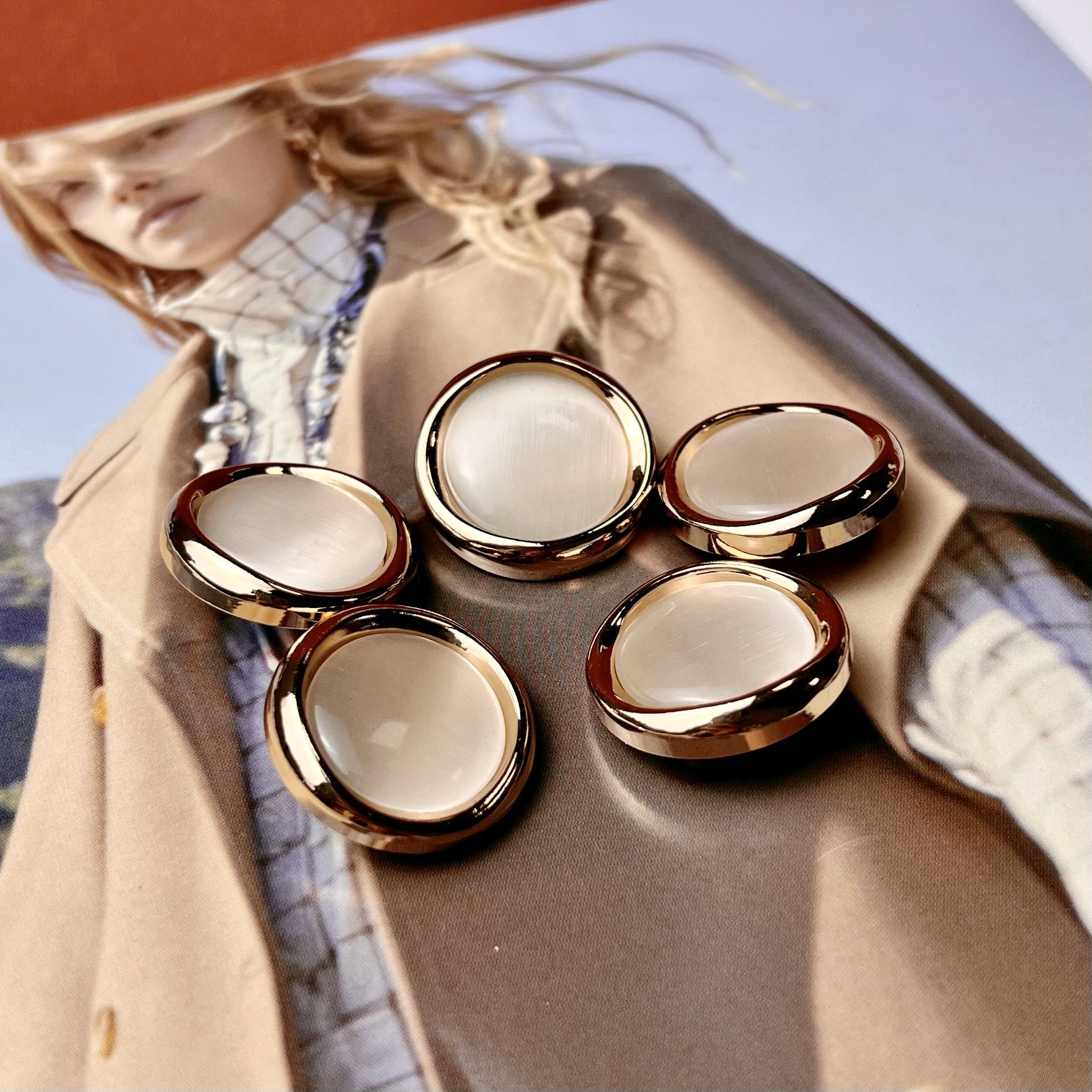 Set of opalescent cat-eye buttons with gold edges and white pearled centers