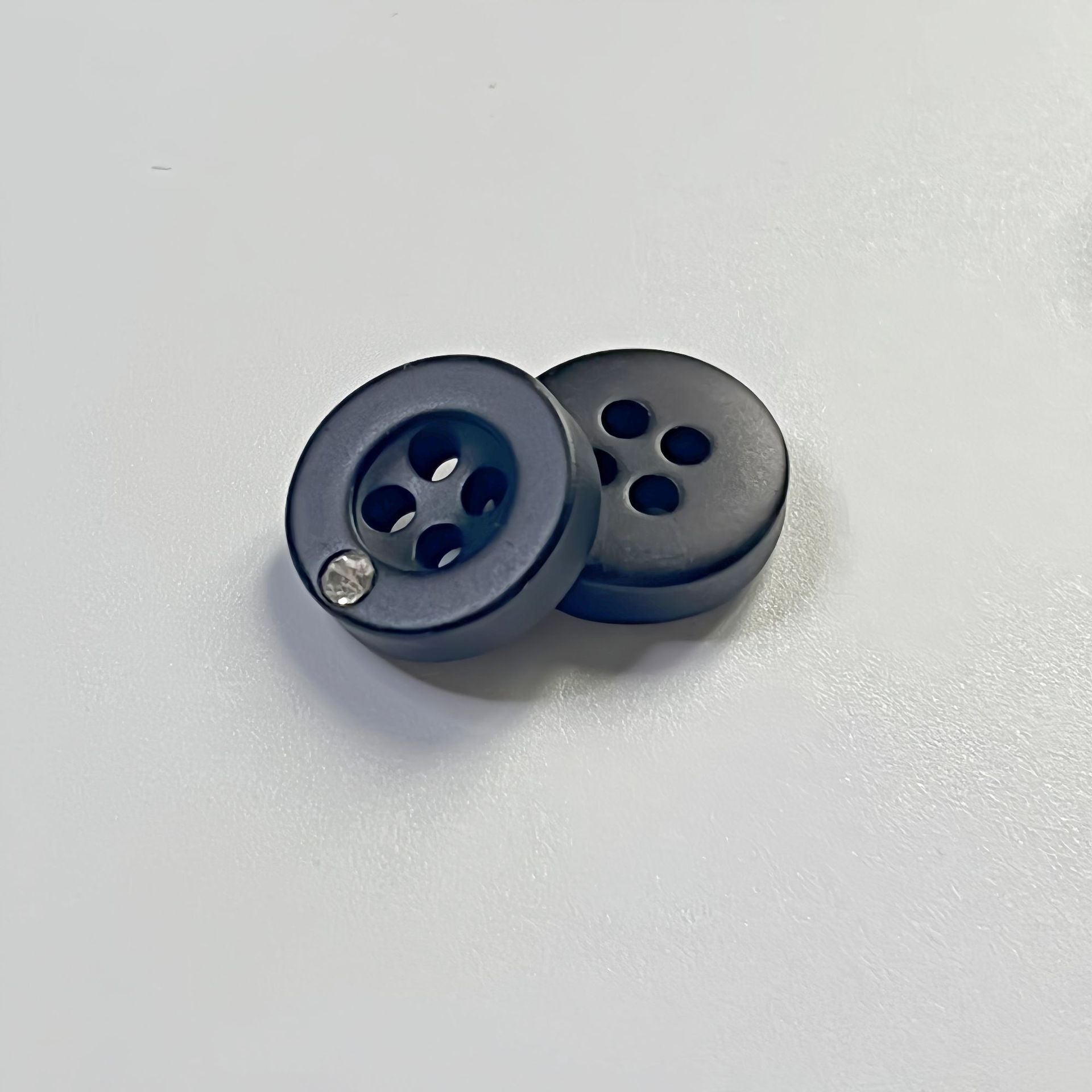 Two black 11mm round 4-hole resin buttons with small rhinestone on rim