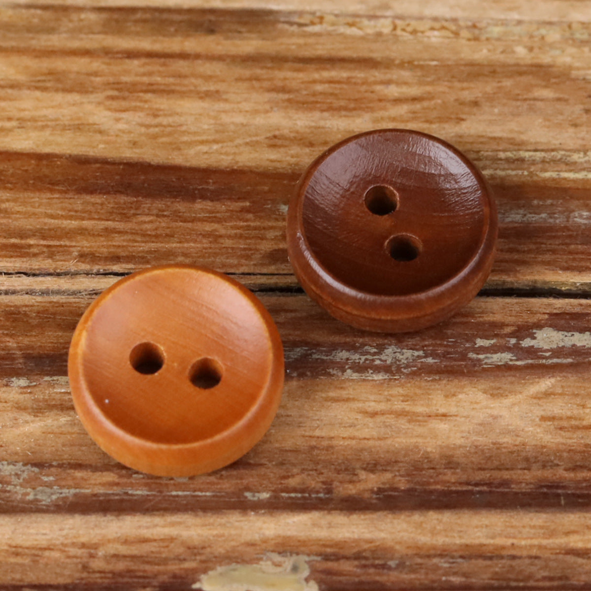 Two round 2-hole wood buttons in dark and light brown.
