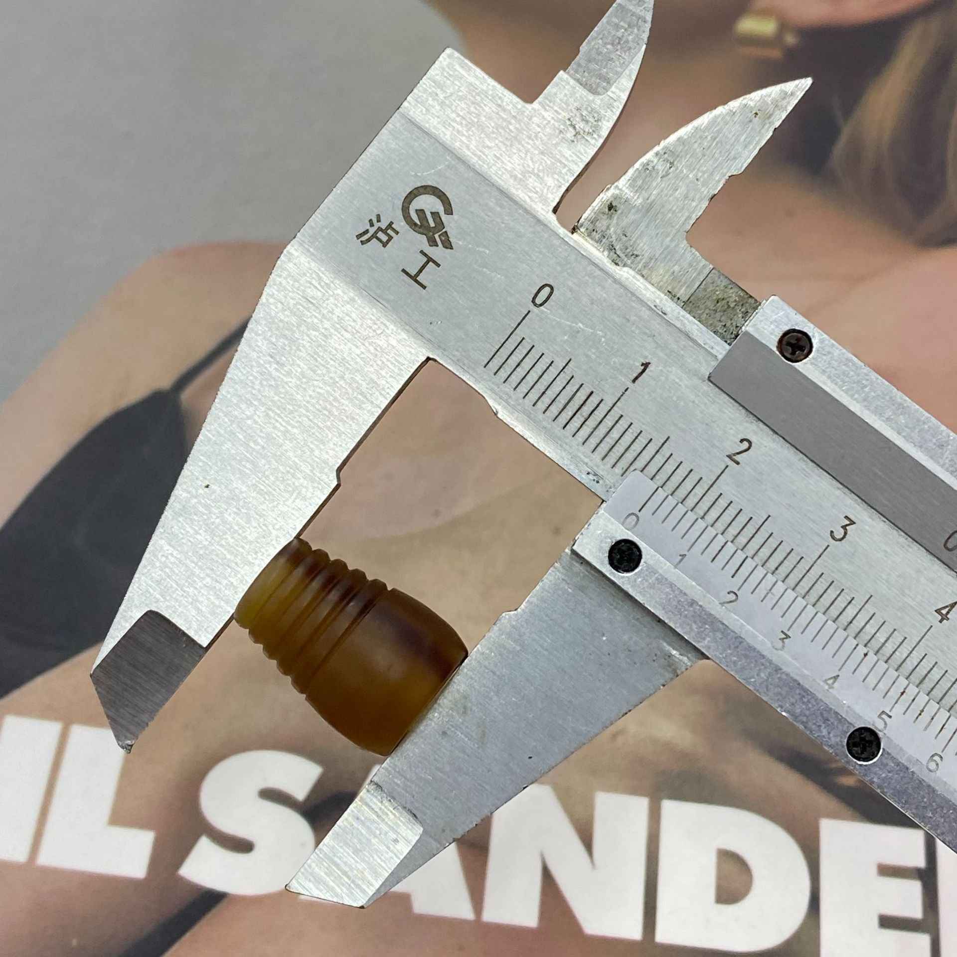 17mm resin cord end stopper measured with caliper; brown ribbed bell end