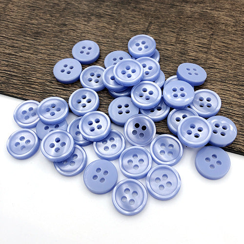 Blue round 4-hole shirt buttons, small round button set on wooden surface