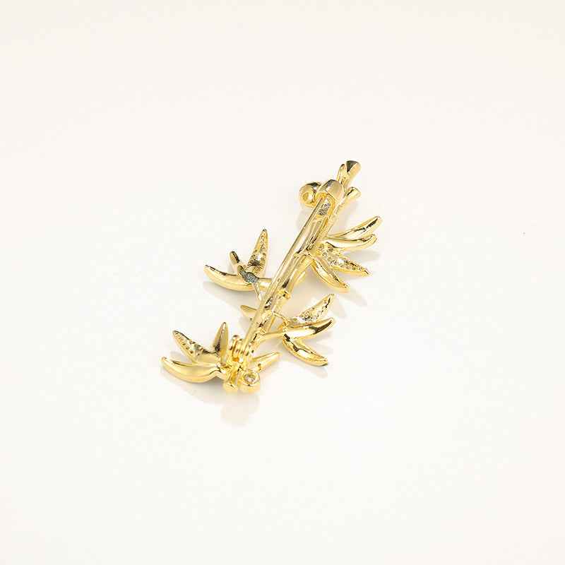 Gold bamboo brooch pin with green enamel leaves and textured gold finish