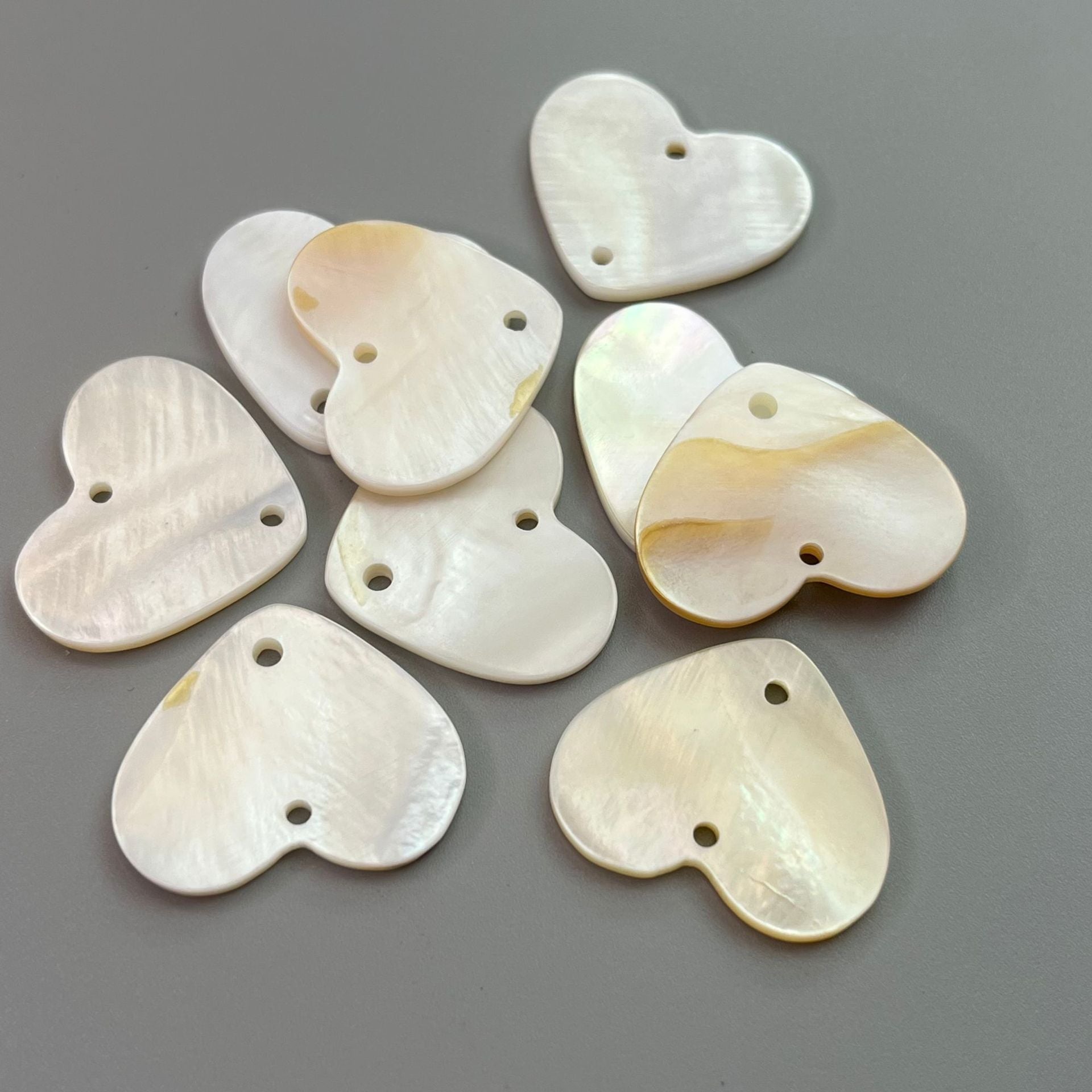 Heart-shaped mother-of-pearl style buttons in white, round backs, 2 holes each.