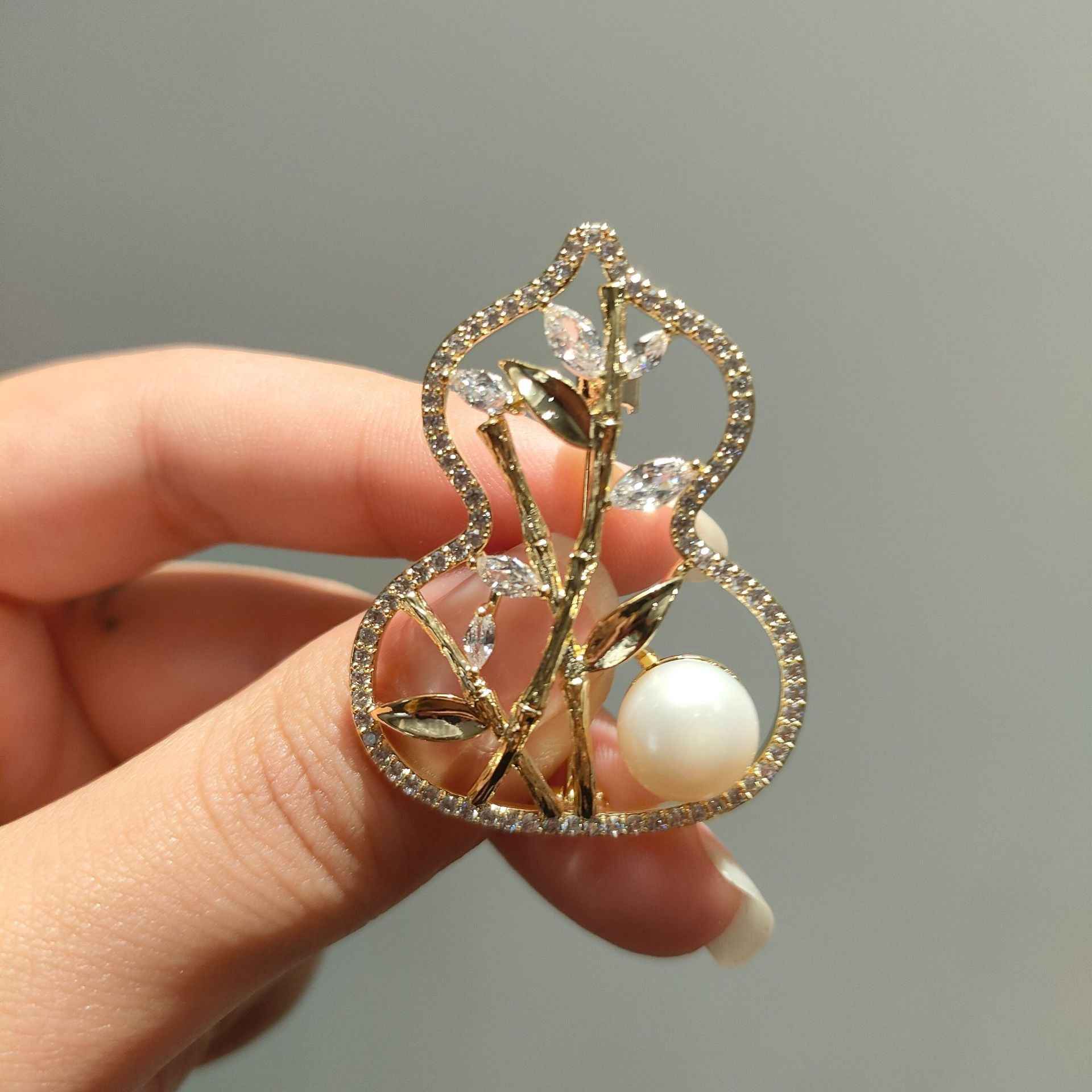 Gold-tone bamboo gourd brooch detail: branch motif with faceted stones and pearl