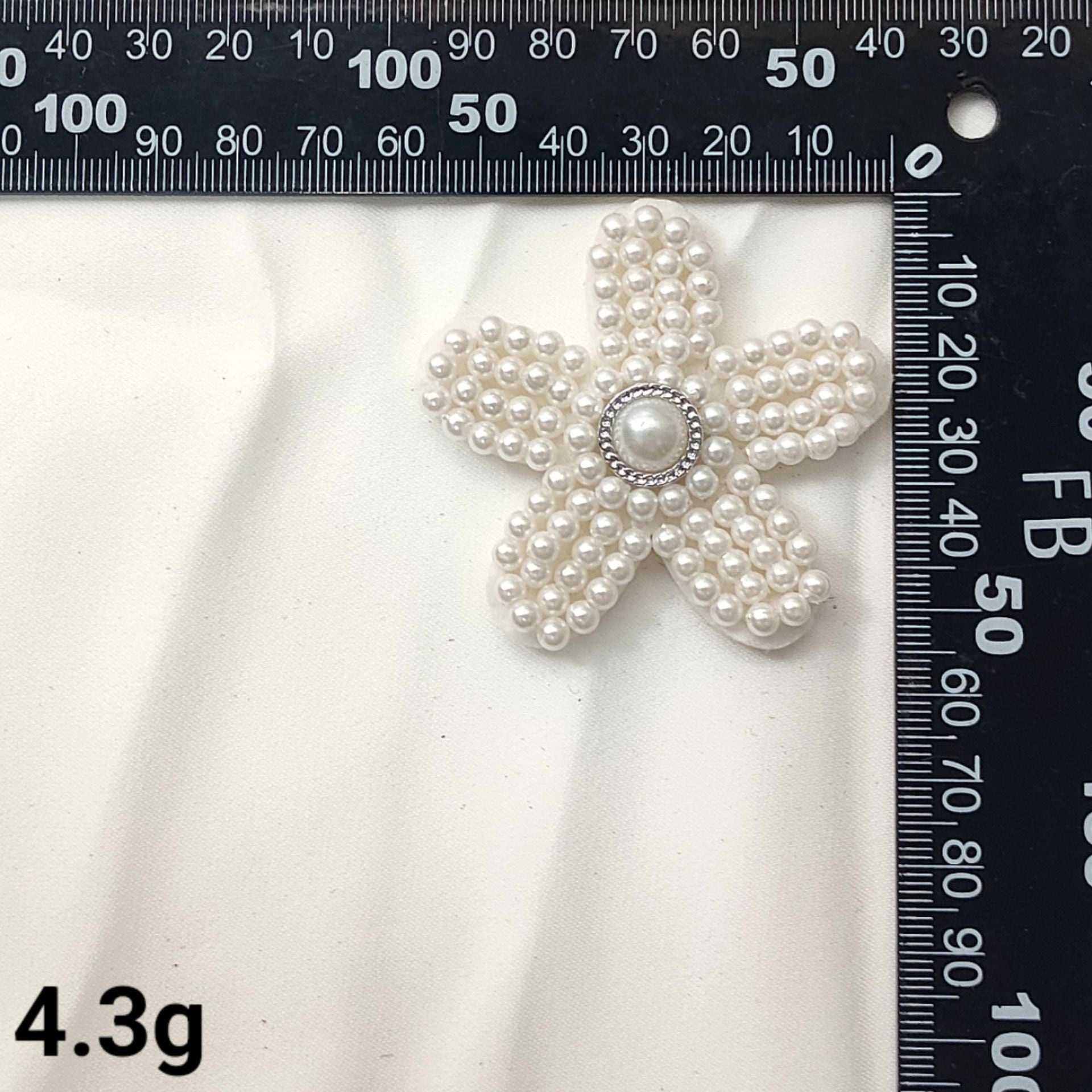 White pearl star patch with round pearl center and curved bead-wrapped arms