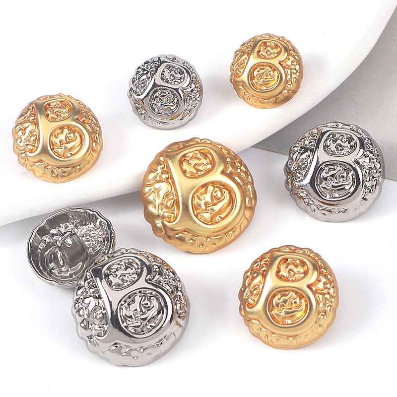 Domed letter B metal shank buttons in gold and silver, embossed ornamental detail