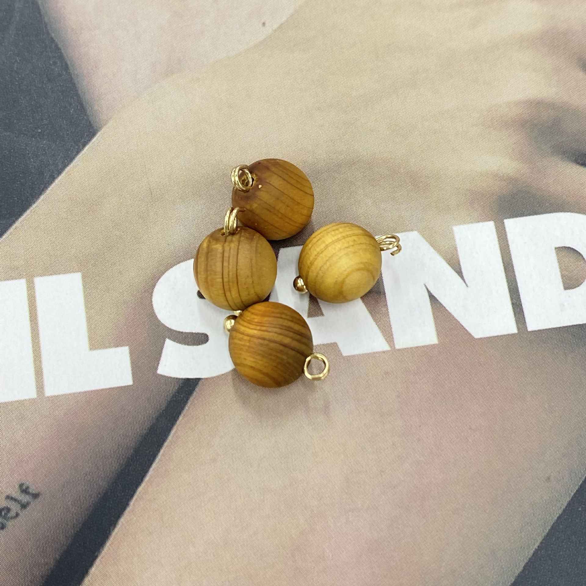 Coffee-colored round wooden buttons, assorted light and medium browns, gold-tone loops