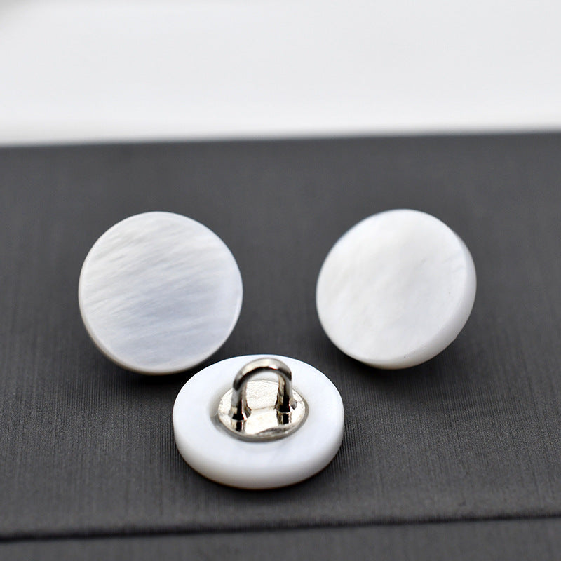 White mother-of-pearl shell round buttons with metal shank, visible back hardware