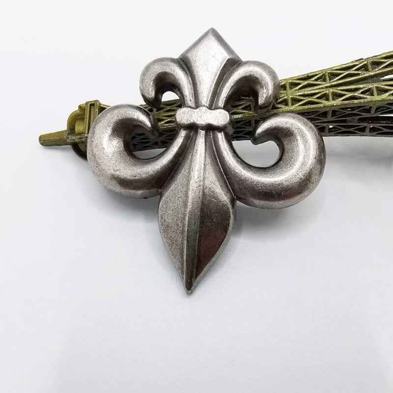 Antique silver Fleur-de-lis stud rivet with pointed petal tips, back insert visible