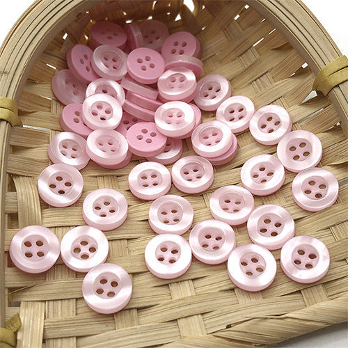 Round 4-hole pearlized resin buttons in pink tones, arranged in a tray (10mm)