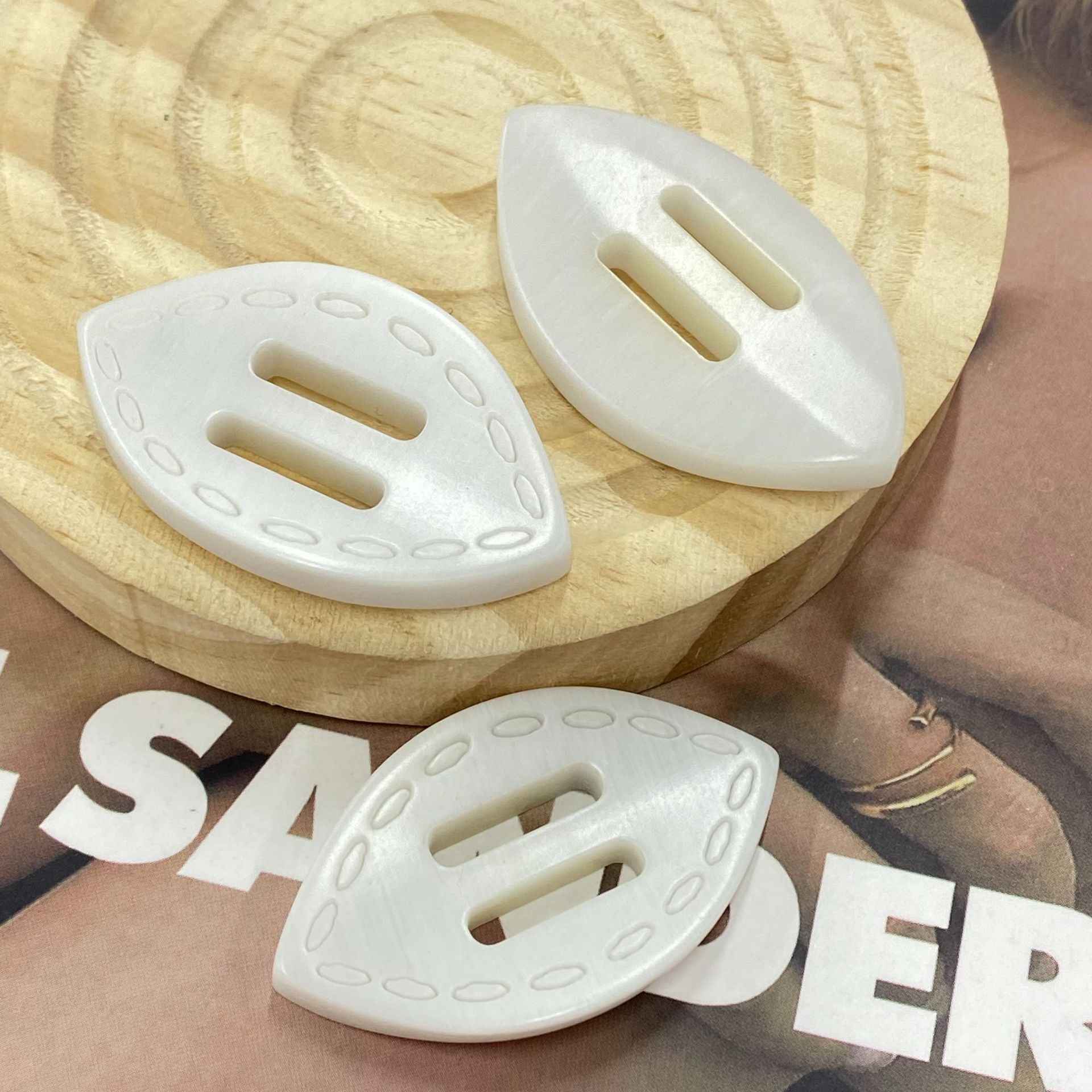 White oval resin 2-hole buckle buttons, front with oval slots, on wooden round