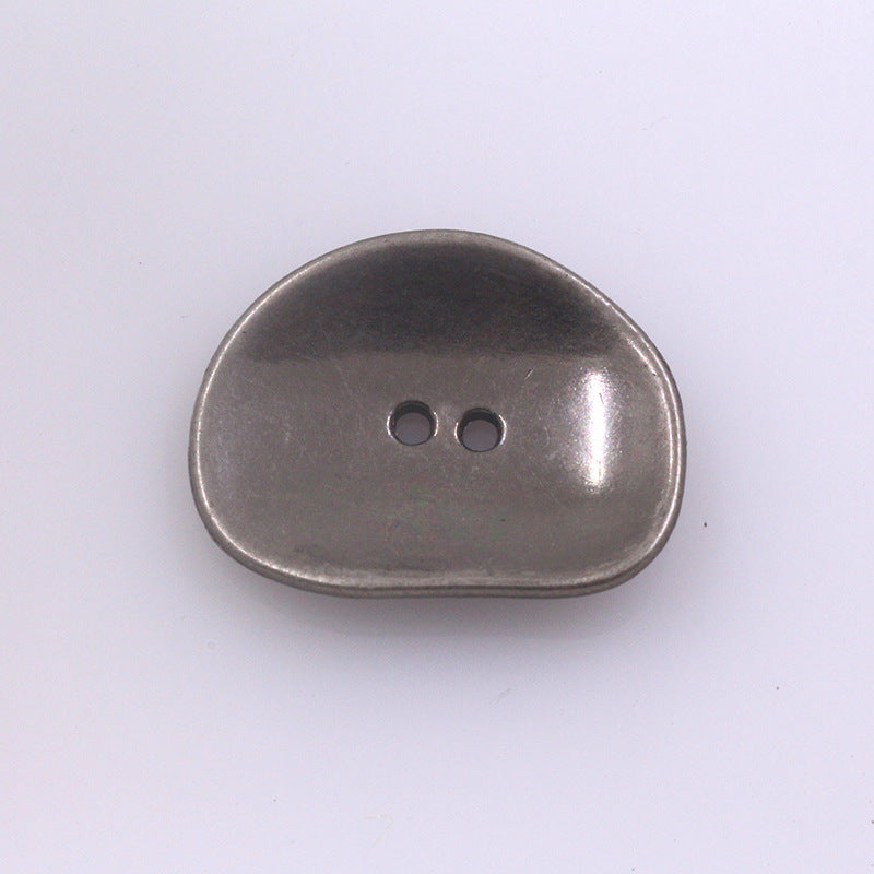Irregular two-hole metal button, dark gunmetal finish, rounded oval shape