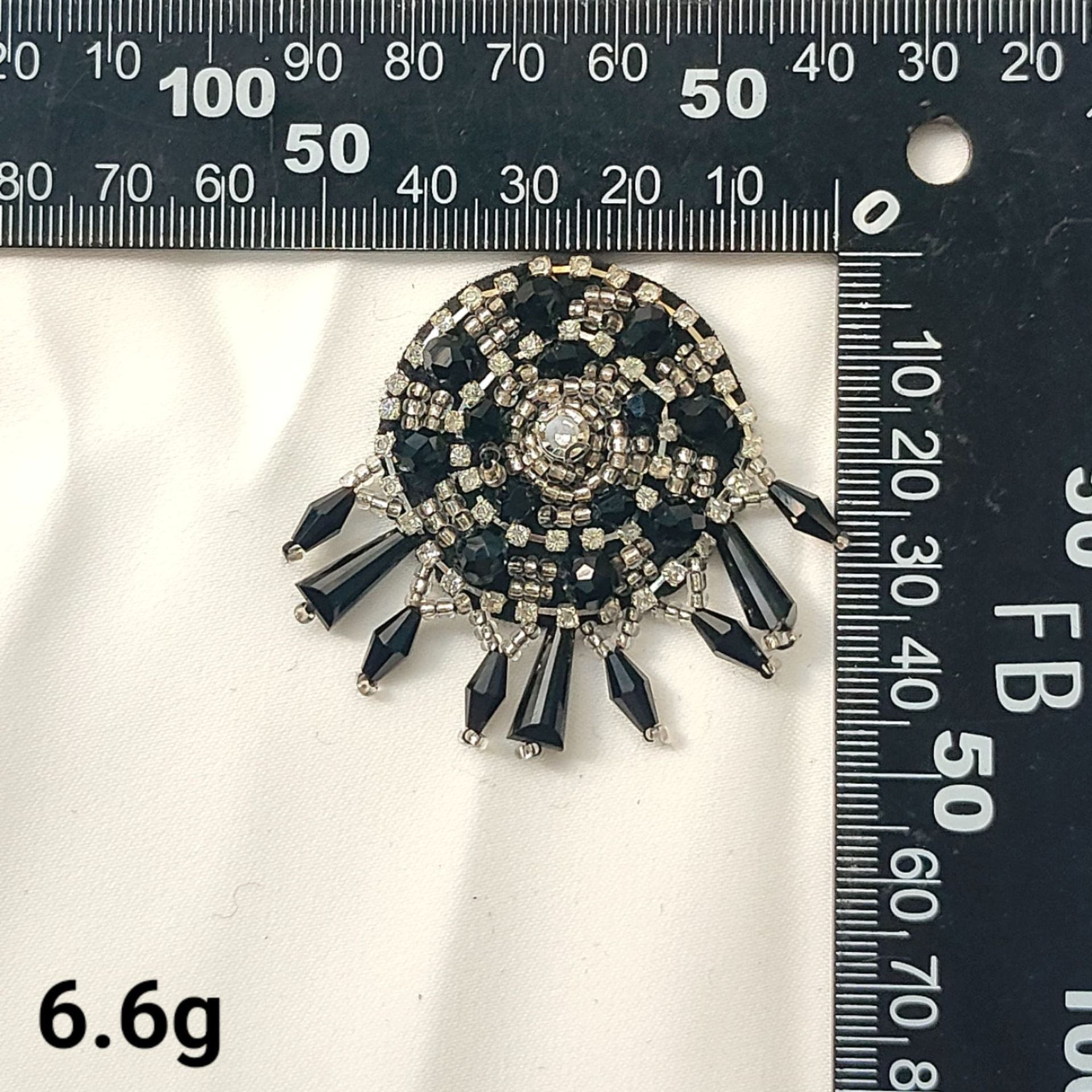 Black round crystal bee patch with scattered dark gemstones and silver beading