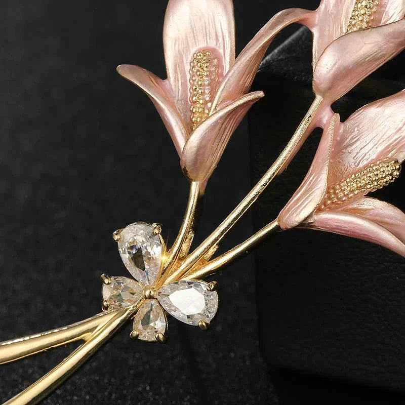 Gold-tone lily brooch with pink enamel petals and sparkling crystal flower center