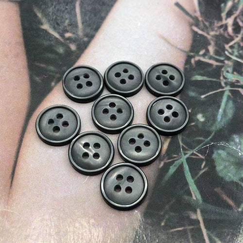Round resin shirt buttons, 4-hole, dark charcoal grey, small group of fronts