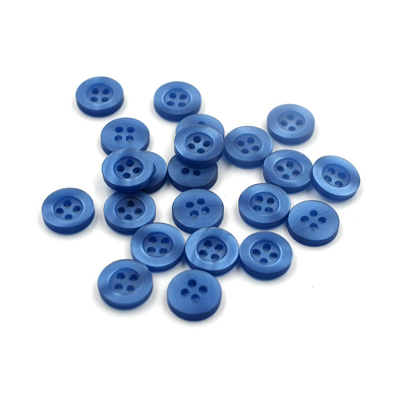 10mm light blue round shirt buttons with four holes, several buttons grouped on white