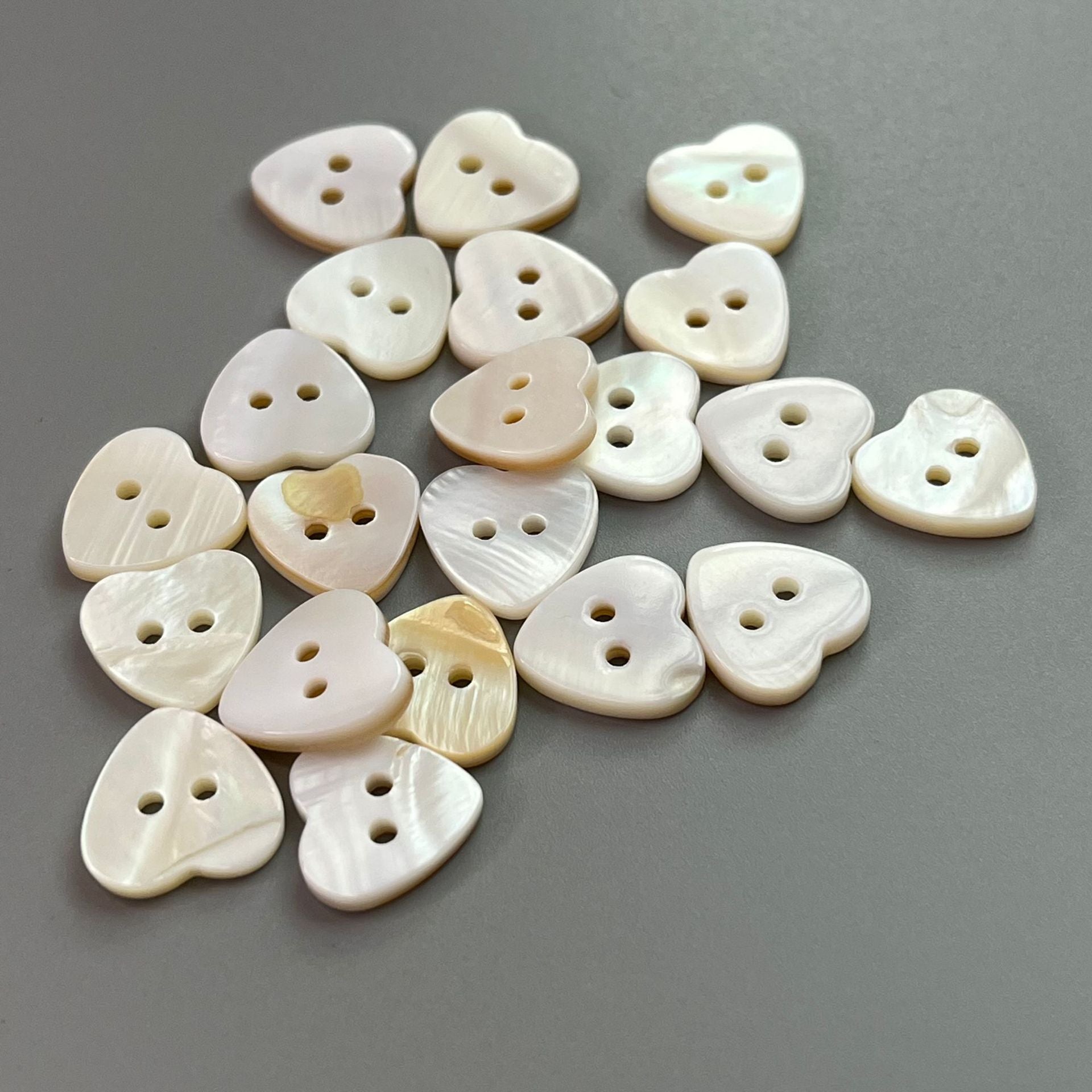 Mixed small heart buttons, white shell look with subtle iridescent sheen, 2 holes.