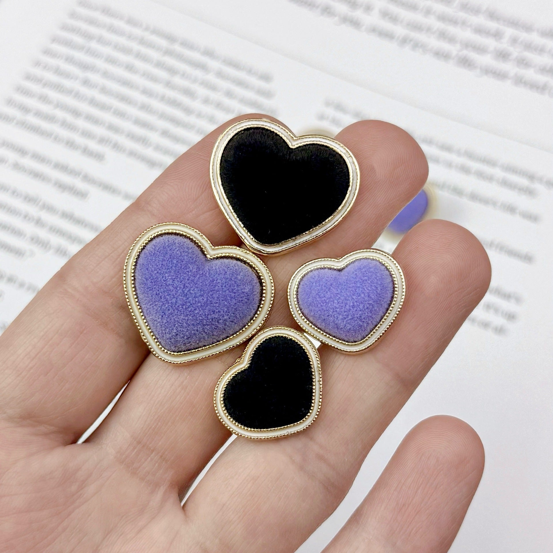 Heart buttons in hand: mix of purple and black flocked hearts with gold-tone edges (20 pcs)
