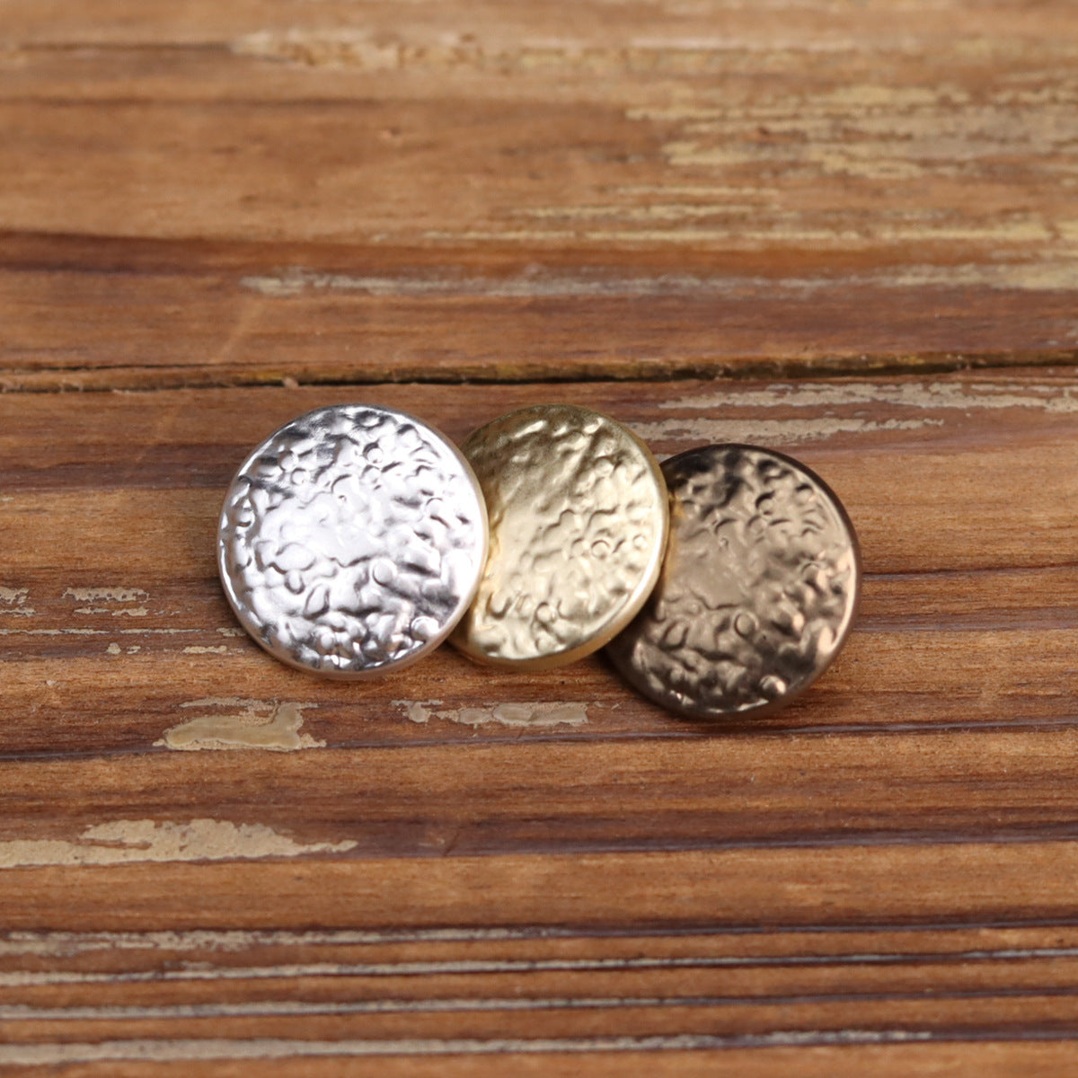 Round metal shank buttons with vintage wave embossing; silver, gold, and dark bronze tones.