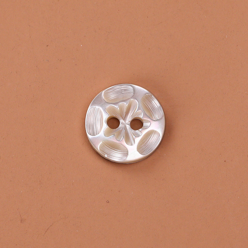 White 2-hole troca shell button with embossed leaf/floral pattern, 11.5mm