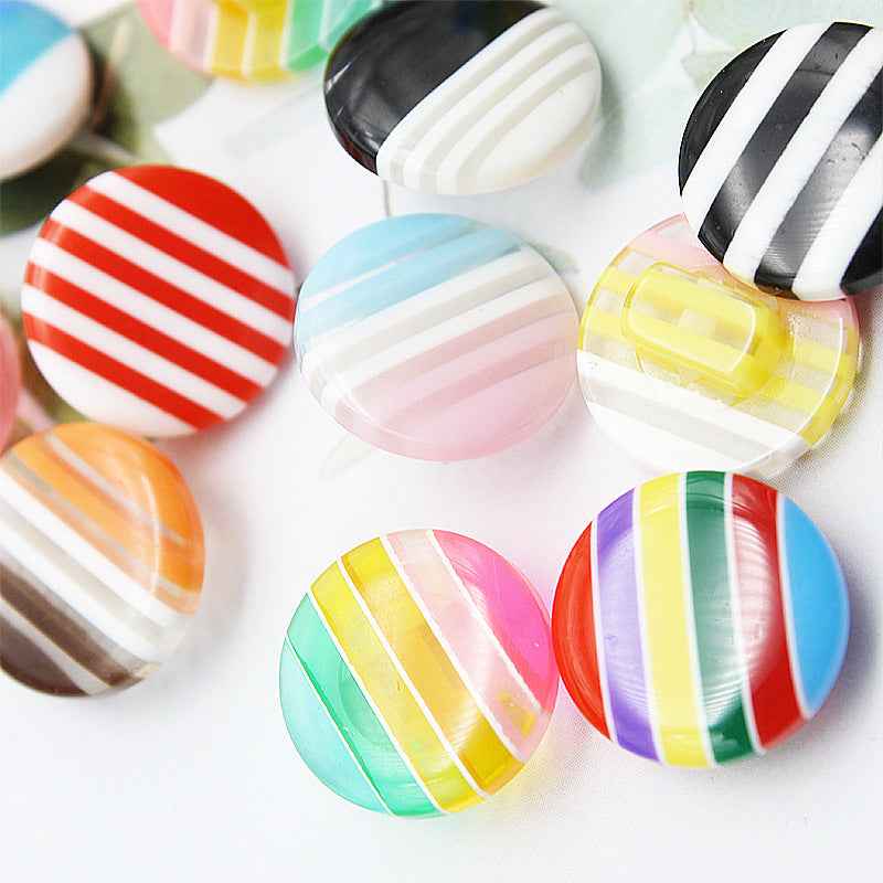 Rainbow striped resin shirt button, red-and-white stripes, round shank, front view.