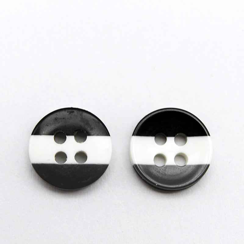 Round resin button with black and white stripes and four holes; simple two-tone look.