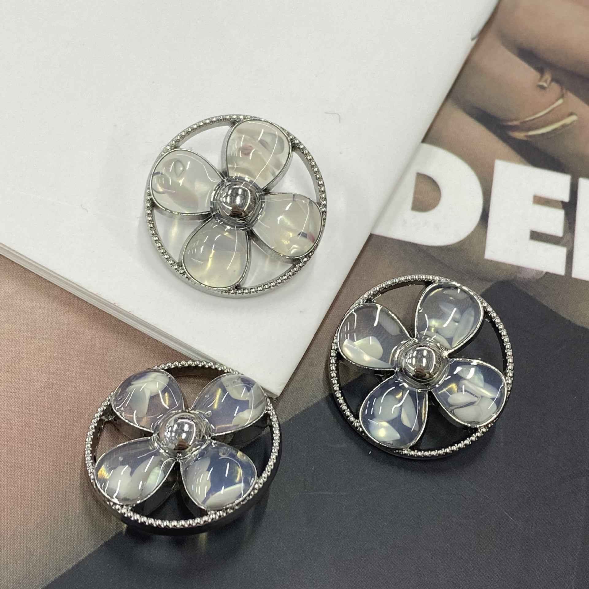 Round clover shank buttons with clear/opal petals, silver-tone rim and 5-petal flower center