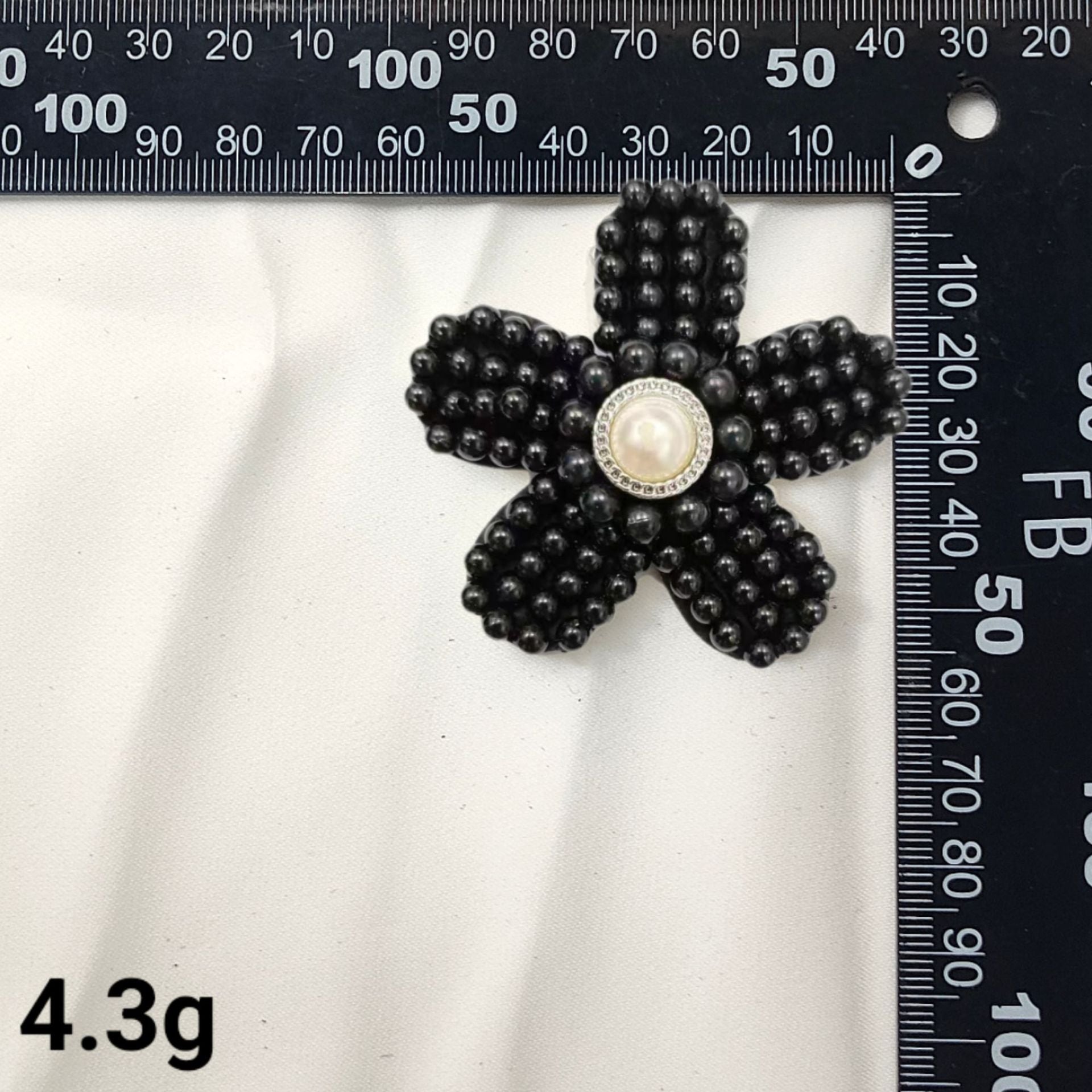 Black bead star patch with round pearl center medallion and clustered raised beads