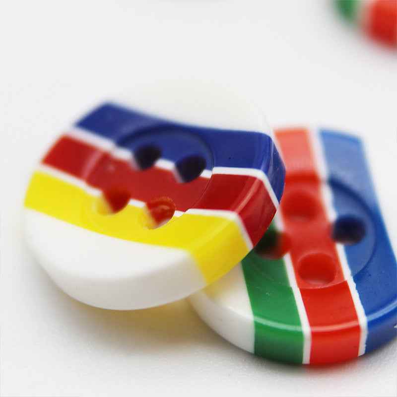 Close-up of round resin buttons with 4 holes, candy stripes: blue, red, yellow