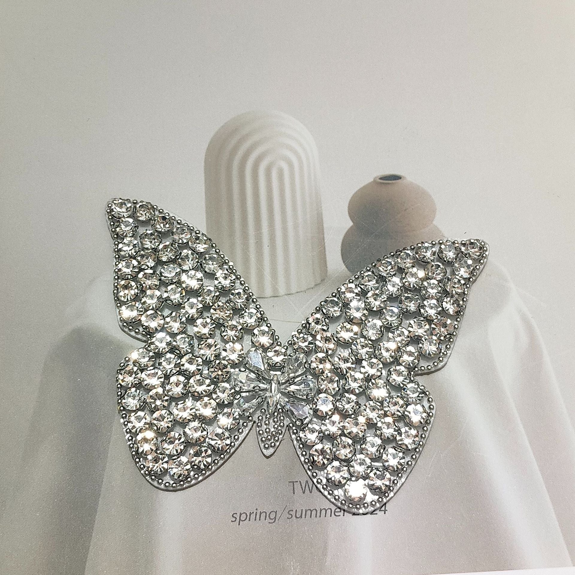 Large silver rhinestone butterfly applique with layered gem wings and chain tassels