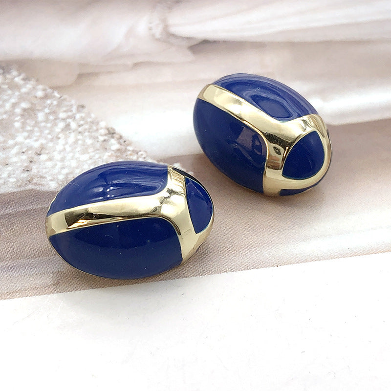 Blue and gold metal shank buttons, oval beetle design, two shown
