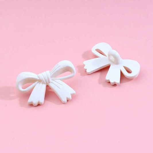 White bow-shaped plastic shank buttons with loop shanks, 2-piece view