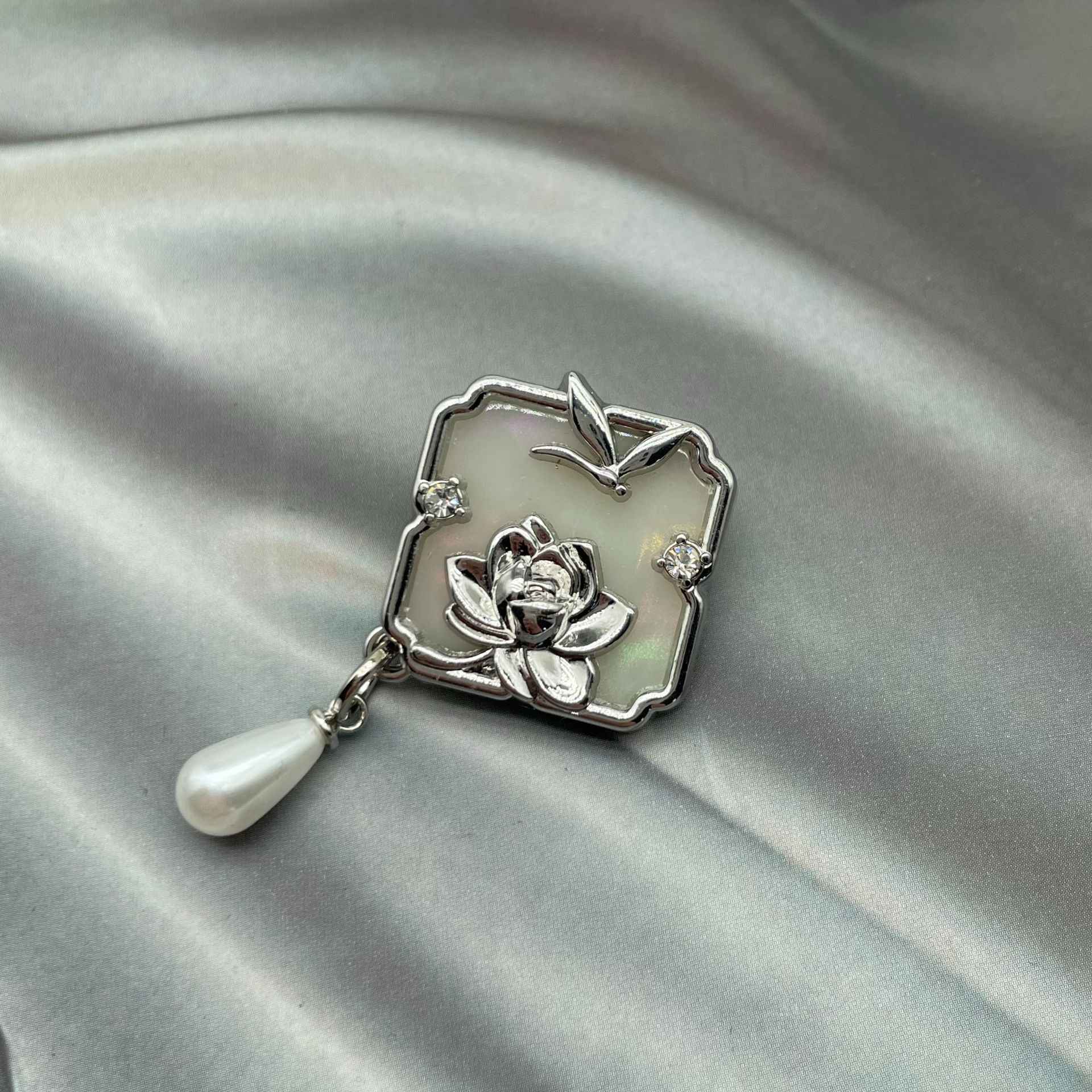 Silver 1-inch metal sew-on button with raised lotus flower, dragonfly shape, rhinestones