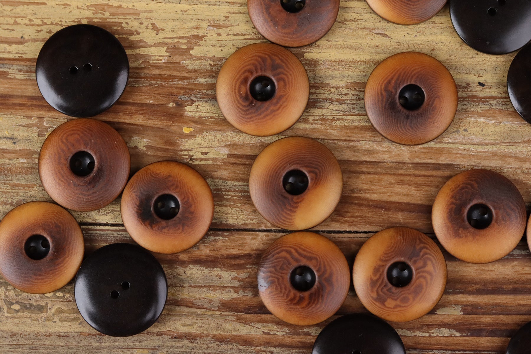 Assorted round two-hole seed buttons in black, dark brown, and amber