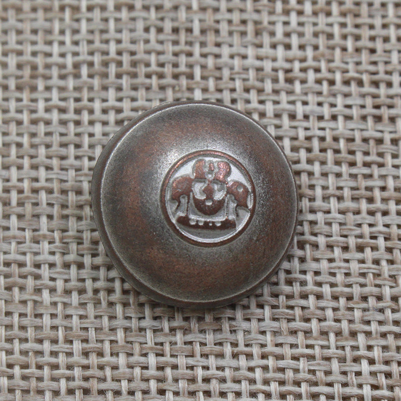 Ein einzelner runder Knopf (dunkelbronze), geprägtes Kronen-Emblem auf der Vorderseite