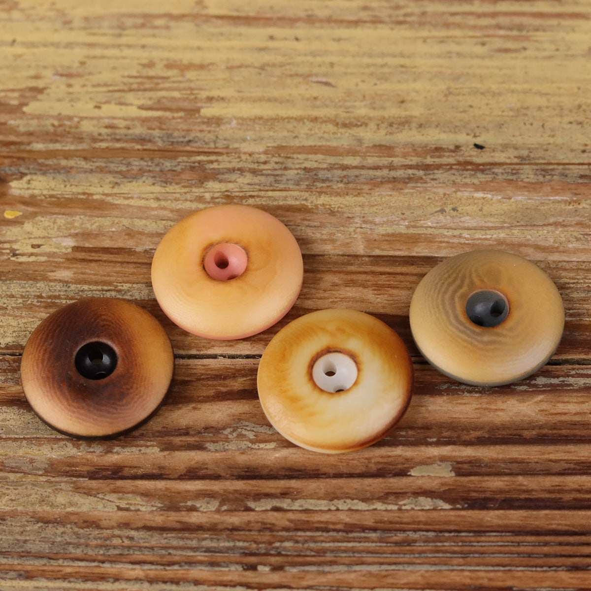 Assorted round two-hole seed buttons with dark, light tan, and caramel tones