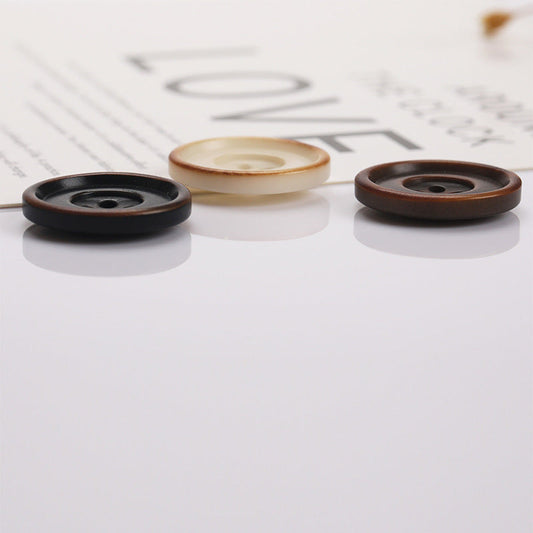 Round two-tone 4-hole sewing buttons: black, beige, and brown outer rim