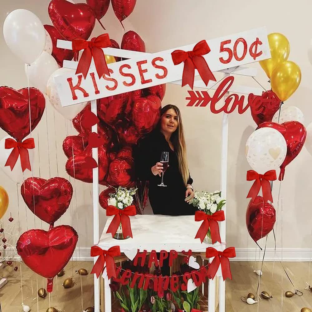 Red cotton ribbon bows and tails decorating a party balloon-and-wreath display