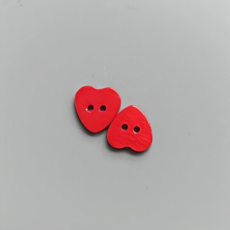 Red heart-shaped 2-hole shirt buttons for children, two buttons shown.