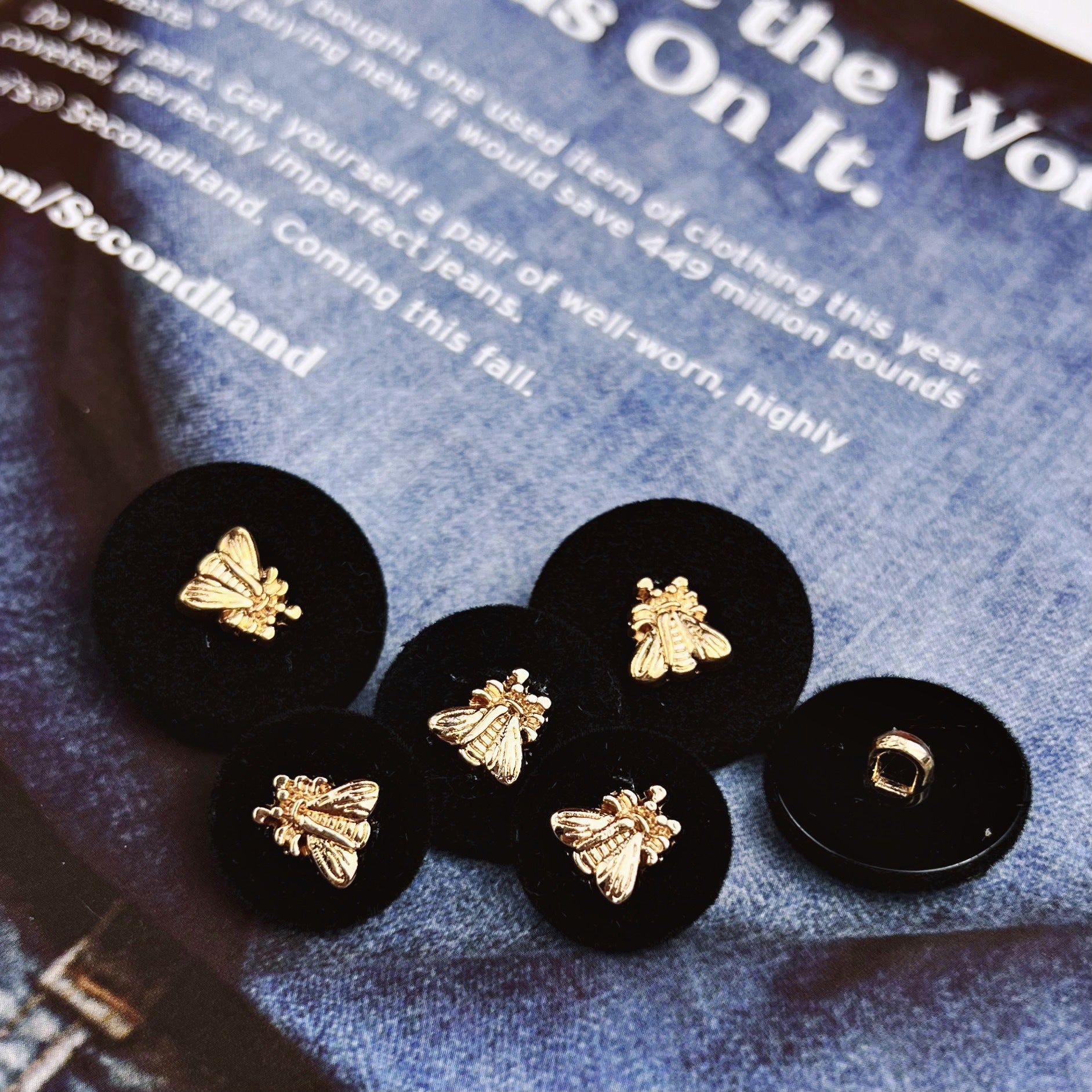 Set of black flocked shank buttons with gold cicada motifs and square center hole