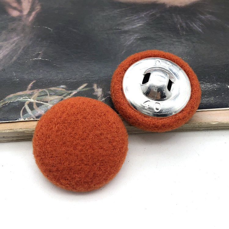 Two 28mm fabric-covered buttons: orange/rust textile face with silver metal snap